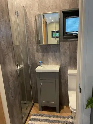 a bathroom with a sink and a shower at Dinas Lodge with private hot tub in Llangollen