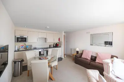 a kitchen and living room with a couch and a table at Fabulous Sea View Apartment in Aberdyfi