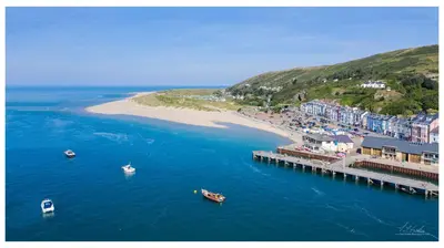 a group of boats in the water near a beach at Fabulous Sea View Apartment in Aberdyfi