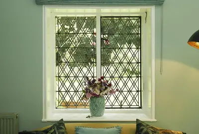 a vase of flowers sitting in front of a window at Bull Hollow Cottage in Shrewsbury