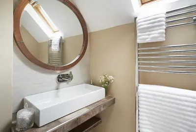 a bathroom with a white sink and a mirror at Bull Hollow Cottage in Shrewsbury