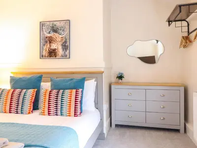 a bedroom with a bed with colorful pillows at Golygfa'r Orsaf Snowdonia National Park in Bala