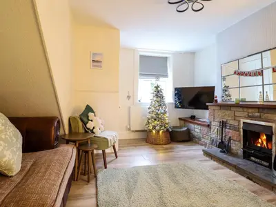 a living room with a christmas tree and a fireplace at Golygfa'r Orsaf Snowdonia National Park in Bala