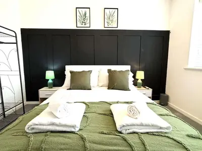a bedroom with a large bed with towels on it at Shrewsbury Stayscape - Modern & Spacious 3BR - Family & Business Ready for 7 by Parydise Properties in Bicton