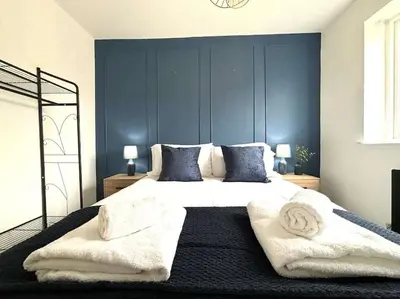 a bedroom with a large white bed with towels on it at Shrewsbury Stayscape - Modern & Spacious 3BR - Family & Business Ready for 7 by Parydise Properties in Bicton