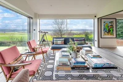a living room with a couch and a table with books at 1 Little Broomcroft in Shrewsbury