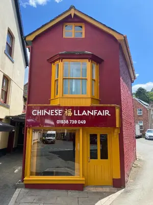 a red building with a yellow door on a street at Fabulous Hot Tub with Views! in Llanfair Caereinion