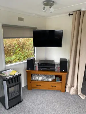 a living room with a flat screen tv and a table at Fabulous Hot Tub with Views! in Llanfair Caereinion