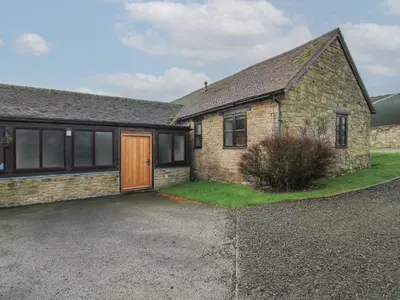 a brick house with a driveway in front of it at Walton Maisonette in Craven Arms