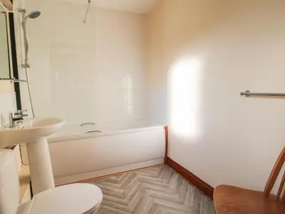 a bathroom with a tub and a toilet and a sink at Walton Maisonette in Craven Arms
