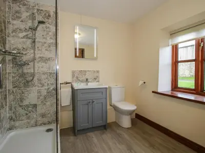 a bathroom with a toilet and a sink and a shower at Walton Maisonette in Craven Arms