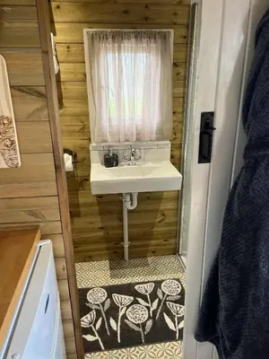 a bathroom with a sink and a window at Ty'r Bugail - Shepherds Hut in Llanddwywe