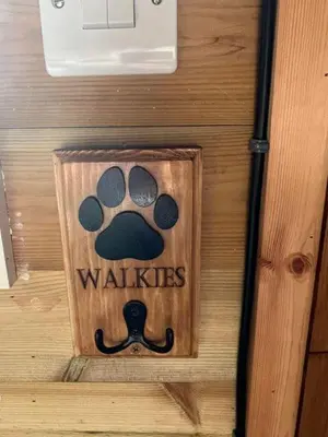 a wooden sign with a paw print and the words walkiates at Ty'r Bugail - Shepherds Hut in Llanddwywe