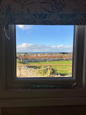 a window in a room with a view of a field at Ty'r Bugail - Shepherds Hut in Llanddwywe