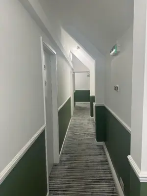 an empty hallway with green and white walls and a hallwayngth at Yak & Yeti in Shrewsbury