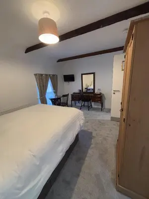 a bedroom with a large bed and a table at Yak & Yeti in Shrewsbury