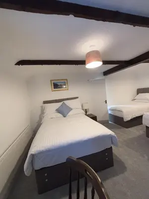 a bedroom with a bed and a chair in it at Yak & Yeti in Shrewsbury
