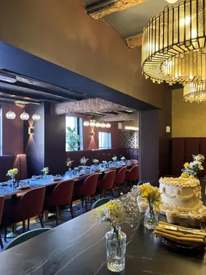 a long dining room with a long table with a cake on it at Yak & Yeti in Shrewsbury