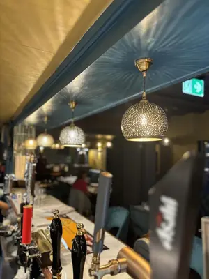 a table with bottles on it in a restaurant with lights at Yak & Yeti in Shrewsbury