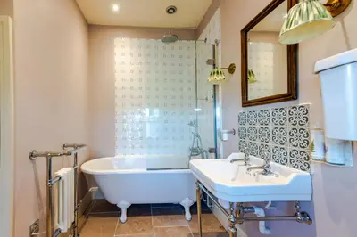 a bathroom with a tub and a sink at The Garden Cottage in Craven Arms