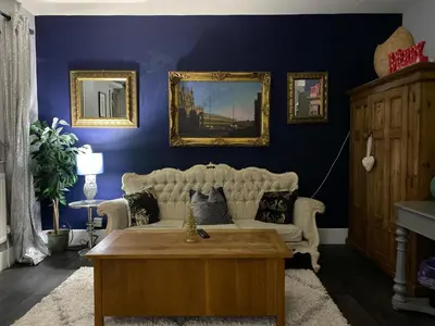 a living room with blue walls and a white couch at Sy3 Shrewsbury in Shrewsbury