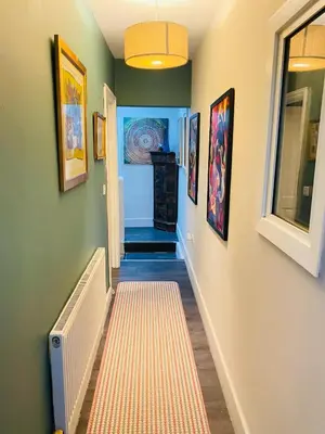 a hallway with a staircase with paintings on the walls at Sy3 Shrewsbury in Shrewsbury