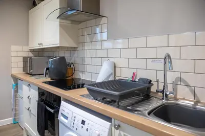a kitchen with a sink and a counter top at Modern Town Centre Apartment in Leominster
