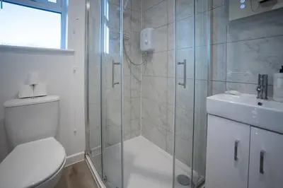 a bathroom with a shower and a toilet and a sink at Modern Town Centre Apartment in Leominster
