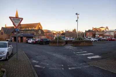 a parking lot with cars parked in a parking lot at Modern Town Centre Apartment in Leominster