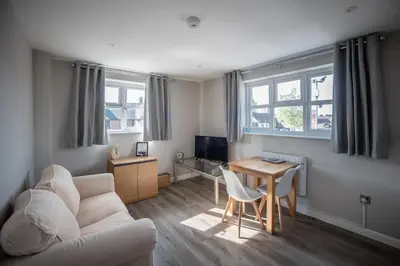 a living room with a couch and a table at Modern Town Centre Apartment in Leominster