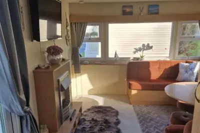 a living room with a couch and a window at 3 Bed Caravan - Sleeps 6 - Pets - Parking - Wifi in Borth
