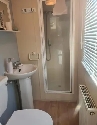 a bathroom with a shower and a toilet and a sink at 3 Bed Caravan - Sleeps 6 - Pets - Parking - Wifi in Borth