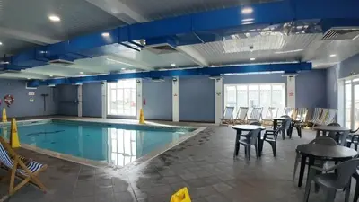 a swimming pool with tables and chairs around it at The Perfect Escape 2 Bedroom Static Caravan Pet Friendly in Aberystwyth