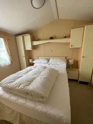 a bedroom with a large white bed with two pillows at The Perfect Escape 2 Bedroom Static Caravan Pet Friendly in Aberystwyth