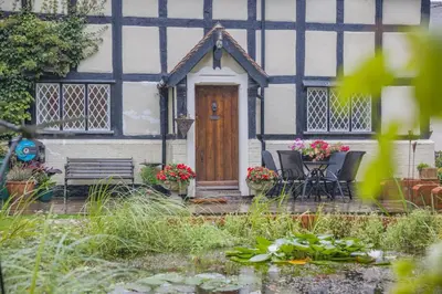a black and white house with a wooden door at 2 Bed in Woofferton oc-b29941 in Woofferton