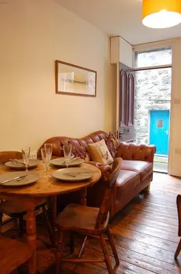 a living room with a table and a couch at Cysgod Idris Cottage in Dolgellau