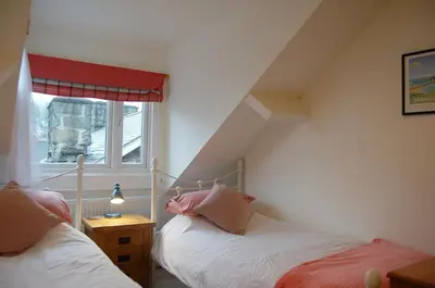 a bedroom with two beds and a window at Cysgod Idris Cottage in Dolgellau