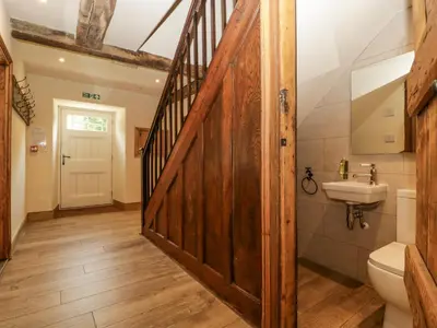 a bathroom with a wooden door and a sink at Evenjobb Court Farmhouse in Presteigne