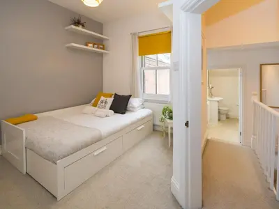 a small bedroom with a bed and a bathroom at Colourful homely 2 bed terrace - Pass the Keys in Shrewsbury