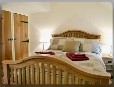 a large bed with a wooden headboard in a bedroom at Awel Yr Mynydd in Ystrad Meurig
