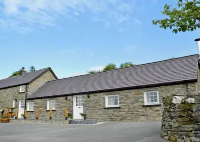 an old stone building with a stone wall at Awel Yr Mynydd in Ystrad Meurig