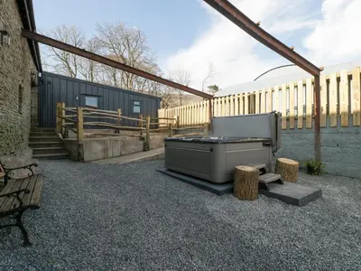 a backyard with a barbecue grill and a wooden fence at White Haywood Barn in Hereford