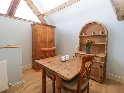 a dining room with a wooden table and chairs at White Haywood Barn in Hereford