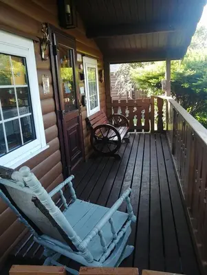 a rocking chair on the front porch of a house at Spyder Ranch in Trawsfynydd
