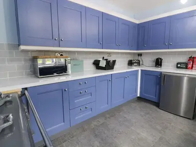 a kitchen with blue cabinets and a microwave at Tan Y Fron in Dyffryn