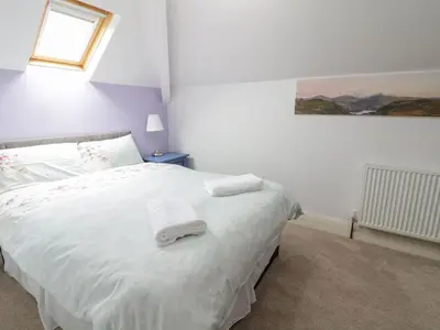 a bedroom with a white bed with towels on it at Tan Y Fron in Dyffryn