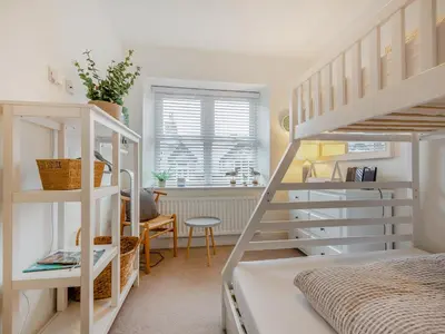 a bedroom with two bunk beds and a desk at Isfryn in Llanbedr