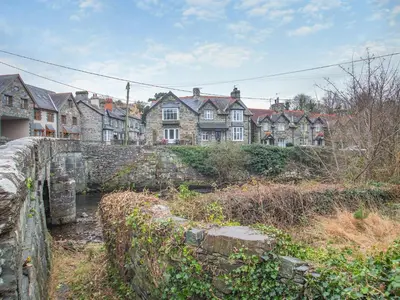a group of houses in a town with a stone wall at Isfryn in Llanbedr