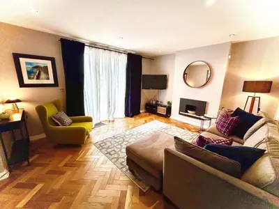 a living room with a couch and a chair at Luxury 2 bedroom town apartment in Aberystwyth
