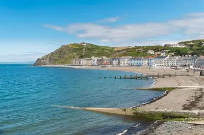 a view of a beach with buildings and the ocean at Luxury 2 bedroom town apartment in Aberystwyth